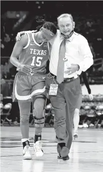  ?? ELSA/GETTY ?? Texas’ Kyra Lambert, left, walks off the court with coach Vic Schaefer after the first half against Maryland on Sunday at the Alamodome.