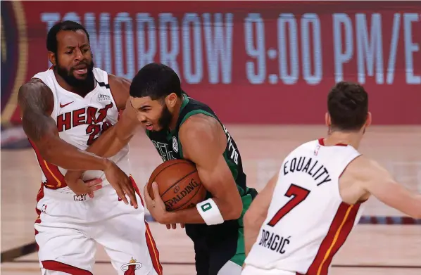  ??  ?? Boston’s Jayson Tatum drives the ball against Miami’s Andre Iguodala in Lake Buena Vista, Florida. Picture: Getty Images