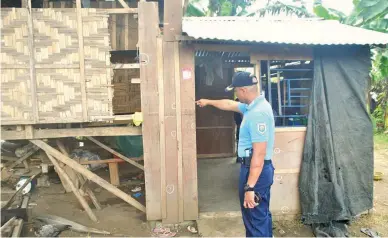  ??  ?? BULLET-RIDDLED – Chief Insp. Julius R. Malcontent­o, police chief of Carmen, North Cotabato, points out the pockmarks left by the brutal slay of a North Cotabato family Monday. The strafing, which also wounded two other members of the Agal family,...