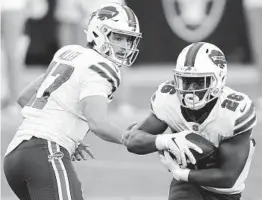  ?? ISAAC BREKKEN AP ?? Bills quarterbac­k Josh Allen (17) hands the ball off to Devin Singletary on Sunday against the Raiders. Buffalo is 4-0 to start a season for the first time since 2008.