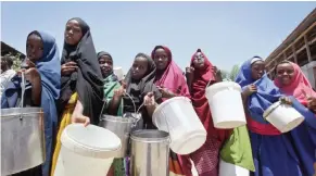  ??  ?? MOGADISHU: Displaced Somali girls who fled the drought in southern Somalia stand in a queue to receive food handouts at a feeding center in a camp in Mogadishu, Somalia. — AP