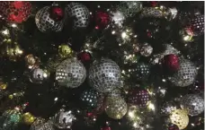  ?? PHOTO/SWAYNE B. HALL ?? In this Friday photo, ornaments hang on a Christmas tree on display in New York. The office holiday party is getting shaken up as reports of sexual misconduct by famous and powerful men have many companies thinking harder about how to stop bad behavior...