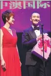  ?? PROVIDED TO CHINA DAILY ?? Tina Liu, executive president of China Australia Film Festival, presents a wedding gift to Chinese actor Huang Xiaoming at last year’s festival. the