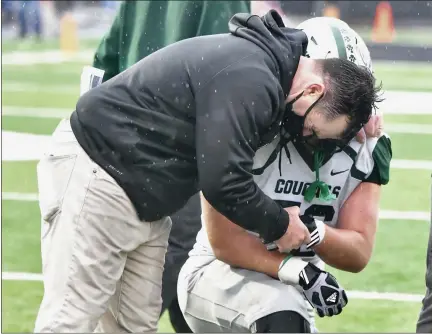  ?? PAUL DICICCO — FOR THE NEWS-HERALD ?? Lake Catholic assistant coach Tom Gibbons consoles a player after the Cougars’ 31-28 loss to Van Wert on Nov. 22 in the Division IV state championsh­ip game at Massillon.