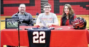  ?? TIMES photograph­s by Annette Beard ?? Britton Caudill signed a letter to play football for Pitt State during a signing ceremony Thursday morning at Pea Ridge. Shown with Caudill are parents Braxton and Brandi Caudill.