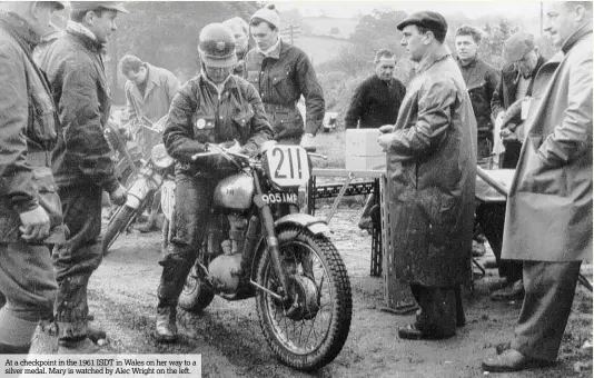  ??  ?? At a checkpoint in the 1961 ISDT in Wales on her way to a silver medal. Mary is watched by Alec Wright on the left.