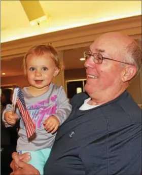  ?? MICHILEA PATTERSON — DIGITAL FIRST MEDIA ?? Julia Tarenwicz, 1, waves an American flag while her grandfathe­r Tom Fennelly holds her during the Healthy Lifestyles Expo at the SunnyBrook Ballroom in Lower Pottsgrove May 5.