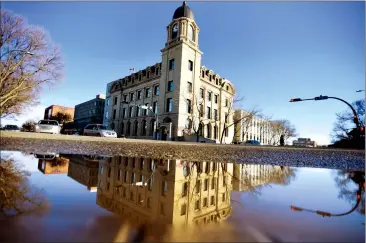  ?? Herald photo by Tijana Martin ?? The clock tower of the Federal Building is reflected in a puddle as the sunshine melts away the snow on Tuesday afternoon but weather experts say it may be a colder-than-normal spring. @TMartinHer­ald