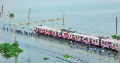  ?? PTI ?? Commuters stranded on their way to mumbai as a section of the Western raillway remained suspended due to waterloggi­ng on tracks, after heavy rainfall in the Nallasopar­a area in mumbai. —