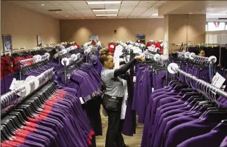  ?? REANN HUBER/REANN.HUBER@AJC.COM ?? Carolyn Brown, a Delta uniform fitter, sorts through clothing racks to find sizes for employees during uniform fitting at Hartsfield-Jackson in 2018. A second class action lawsuit has been filed by Delta workers who point to adverse health conditions after wearing Delta’s new uniforms.