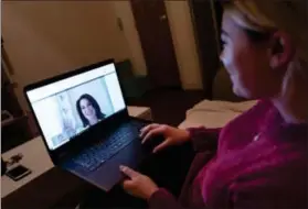  ?? MARK LENNIHAN — THE ASSOCIATED PRESS ?? Caitlin Powers sits in the living room of her Brooklyn apartment in New York, and has a telemedici­ne video conference with physician, Dr. Deborah Mulligan.