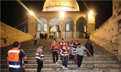  ??  ?? Palestinia­n medics evacuate a wounded person after clashes in Jerusalem’s al-Aqsa mosque compound on 10 May 2021. Photograph: Ahmad Gharabli/AFP/Getty Images