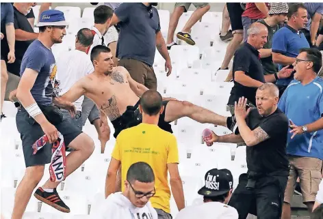  ?? FOTO: AP/THANASSIS STAVRAKIS ?? In der Offensive: Zwei russische Hooligans attackiere­n bei der EM in Frankreich englische Fans in Marseille.
