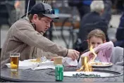  ?? KARL B DEBLAKER — THE ASSOCIATED PRESS ?? Eden Maracco, 8, has lunch her dad Jeffery while power is out at her home, at Reds Food Truck Corner in Southern Pines, N.C., on Monday.