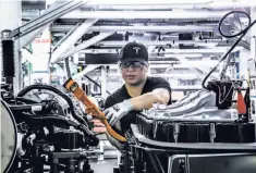  ?? Christie Hemm Klok / New York Times ?? A Tesla employee works at the part of the Model 3 assembly line where the marriage of the battery and car take place.