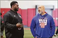  ?? Chris Seward / Associated Press ?? Tackle Ikem Ekwonu, left, talks with Bobby Johnson of the Giants during North Carolina State Pro Day on March 29 in Raleigh, N.C.