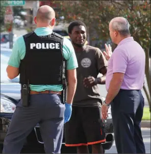  ?? The Sentinel-Record/MARK GREGORY ?? Hot Springs Police Department detectives talk with shooting suspect Demarion Banks (center) in the Police Department parking lot after Monday’s gunfire.