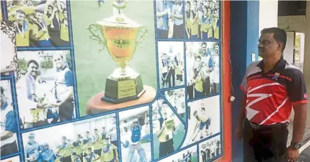  ??  ?? Proud moment: Dominig looking at the “hall of fame” for his students who have excelled in hockey since he introduced the sport in his school in 2018.