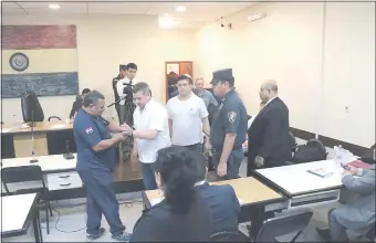  ??  ?? Un policía retira las esposas de Tomás Rojas, al llegar a la sala de juicio. Fue ayer.