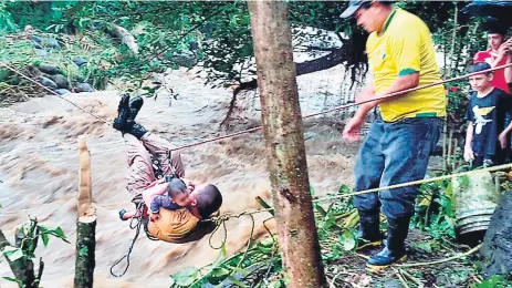  ??  ?? LABOR. El cabo René Alvarado Peña cuando rescataba a una de las niñas de las embravecid­as aguas del río Cuyamelito.