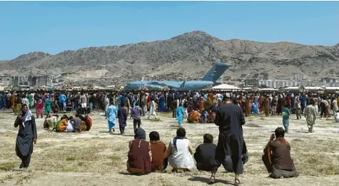  ?? Foto: dpa ?? Hunderte von Menschen versammelt­en sich in der Nähe eines Transportf­lugzeugs der US‰Luftwaffe in Kabul.