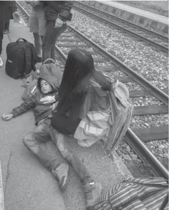  ?? JOE KLAMAR/AFP/GETTY IMAGES ?? A woman assists a boy who fainted as hundreds of people forced their way toward a train in Nickelsdor­f, Austria, near the Hungarian border on Friday. Each day, thousands of people have passed through the train station.