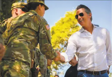  ?? Daniel Kim / Sacramento Bee ?? Gov. Gavin Newsom meets with members of the National Guard in Colfax (Placer County). The governor added nearly 400 seasonal firefighte­rs to the state force on Wednesday.