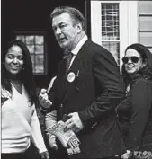  ?? STEVE HELBER/AP ?? Alec Baldwin and Democratic candidate Amanda Pohl, right, knock on doors Tuesday in Virginia.