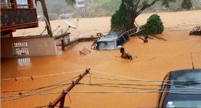  ?? AFP ?? A house and a vehicle is sumbergef in the flooded street in Regent near Freetown. —