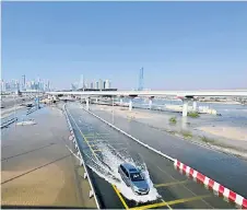  ?? ?? A car is driven in a flooded road following heavy rains in Dubai.