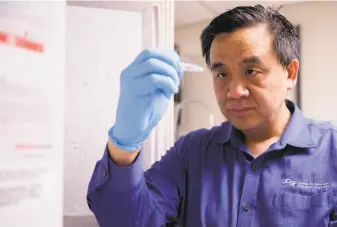  ?? Jessica Christian / The Chronicle ?? Dr. Charles Chiu looks at a sample stored in the laboratory freezer at UCSF Medical Center at Mission Bay. He is working with Mammoth Bioscience­s on a coronaviru­s test.