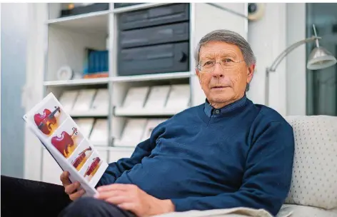  ?? FOTO: OLIVER DIETZE ?? Norbert Hartmann zu Hause. In der Hand hat er die Instrument­en-Broschüre der Stiftung für Alte Musik im Saarland, deren Vorsitzend­er er ist.