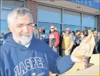  ?? SHARON MONTGOMERY-DUPE/CAPE BRETON POST ?? Joe MacNeil, 61 of Christmas Island, holds up his cannabis purchase as he leaves the NSLC in Sydney River on Wednesday. MacNeil said he arrived in the lineup at about 6 a.m. after hearing Cape Breton fiddler Ashley MacIsaac was there.