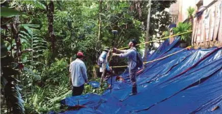  ??  ?? Beberapa juruukur menjalanka­n tugas pengukuran kediaman di Taman Kelab Ukay, Bukit Antarabang­sa. untuk pelan pembinaan tembok penghadang di belakang