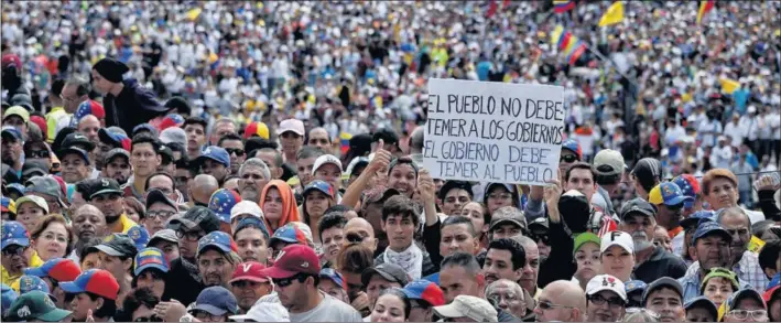  ?? / FEDERICO PARRA (AFP) ?? Un grupo de manifestan­tes contra el Gobierno de Nicolás Maduro se concentra ayer en Caracas durante el discurso de Juan Guaidó.