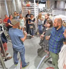  ?? JOHN KLEIN / FOR THE JOURNAL SENTINEL ?? People gather around David Dupee as he talks about the brewing process at Good City Brewing.