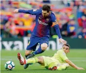  ?? AP ?? Barcelona player Lionel Messi (left) vies for the ball with Mathieu Flamini of Getafe during their Spanish league match at the Camp Nou stadium in Barcelona. —