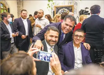  ?? Francine Orr Los Angeles Times ?? ROBERT LUNA, center, poses for photos with supporters at an election night celebratio­n in Long Beach. He received the endorsemen­ts of all five county supervisor­s and of the candidates he beat in the June primary.