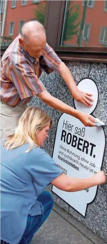  ?? FOTO: SCHNEIDER/BIP ?? Sozialarbe­iterin Sarah Jochum und Hausbewohn­er Holger Becker kleben ein erstes Plakat.