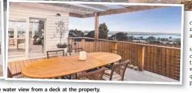  ??  ?? COASTAL STUNNER: The home’s luxe modern kitchen and the water view from a deck at the property.