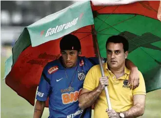  ?? Irandy Ribas - 1º.nov.2012/Tribuna/Folhapress ?? Eduardo Musa (à dir.) segura guarda-sol para Neymar, que jogava no Santos na época