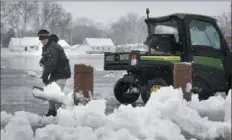  ?? Scott Olson/Getty Images ?? A worker clears snow around Lambeau Field on Wednesday in Green Bay, Wis. A heavy, wet snow blanketed much of northeaste­rn Wisconsin, with as much as a foot expected in some areas.