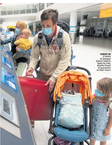  ??  ?? CHECK IN A family at Glasgow Airport head to Spain for hols, despite threat of quarantine on their return