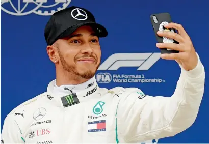  ?? AFP ?? Mercedes’ British driver Lewis Hamilton takes a selfie after taking the pole position. —