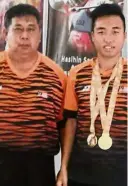  ??  ?? Proud day: Eddy Bernard (right) posing with the two gold medals he won in the Asian Youth Para Games in Dubai with his coach Tony Sawan.