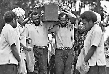  ??  ?? The coffin of Chris Solomon being carried into his village of Pilikambi in the highlands province of Enga.