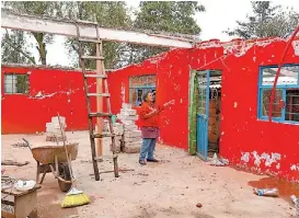  ??  ?? Una mujer observa su vivienda que quedó inhabitabl­e.