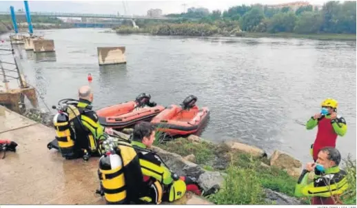  ?? JAVIER CEBOLLADA / EFE ?? Bomberos de Zaragoza que participan en la búsqueda del niño desapareci­do, ayer en la orilla del río Ebro.