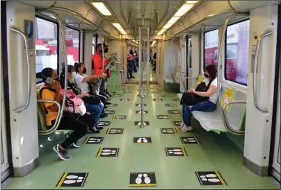  ?? The Associated Press ?? GRAPHIC CUES: Commuters travel on a train marked with social distancing graphic cues on June 8 amid the new coronaviru­s pandemic in Medellin, Colombia. The metropolis recently went five weeks without a single COVID-19 death.