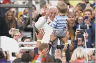  ?? Mindaugas Kulbis / Associated Press ?? Pope Francis reaches out to greet a child during his meeting with youths at the Cathedral Square in Vilnius, Lithuania on Saturday. Pope Francis begins a four-day visit to the Baltics amid renewed alarm about Moscow’s intentions in the region it has twice occupied.